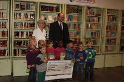 Kinder der KiTa Glockenblumenweg freuen sich mit Jutta Hetfleisch-Brandt, ehrenamtliche Leiterin des Bücherwurms in Holweide, über die Spende in Höhe von 1.000,- Euro, überreicht von Marc Smolarek, Vorstandsvorsitzender der Volksbank Dünnwald-Holweide. 