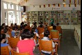 Lesung mit WM Dekoration. Die Leiterin der Bücherei bereitet die Kinder auf die Vernastaltung vor.