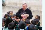 Bischof Sebastian in der Schule bei einer seiner Lieblingsaufgaben: "Bonbons verteilen!"